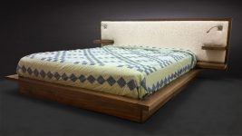 Walnut Platform Bed with sheepskin headboard floating shelves and a reading light